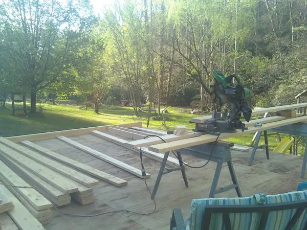 Miter saw and framing lumber on a deck under construction in Coolidge